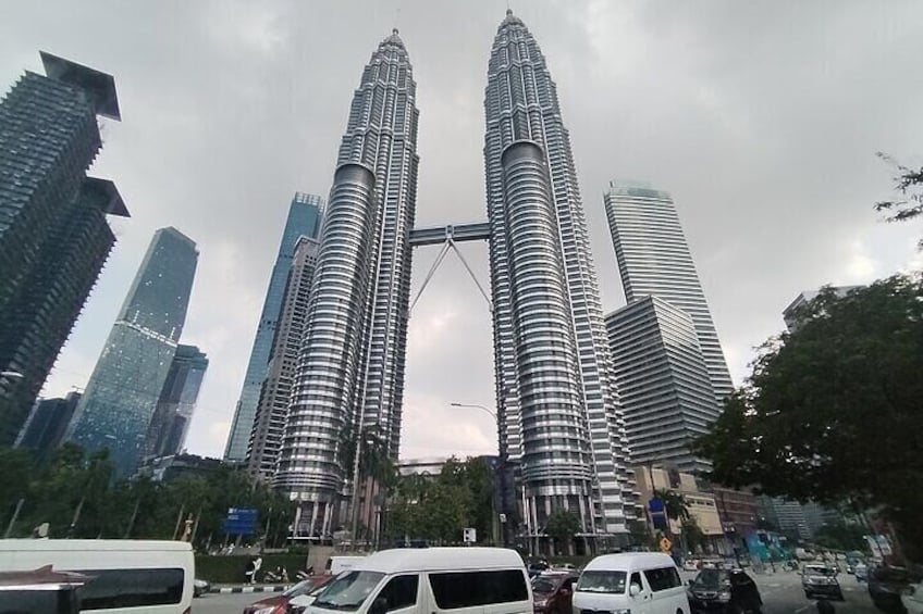 De Petronas Twin Towers in Kuala Lumpur, omringd door moderne wolkenkrabbers en levendige verkeersdrukte. 1
