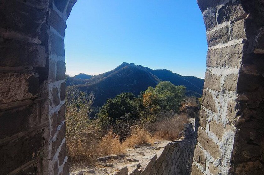 A stone wall with a view of a mountain range. 3