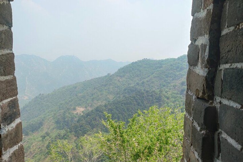 A mountainous landscape with a brick wall in the foreground. 2