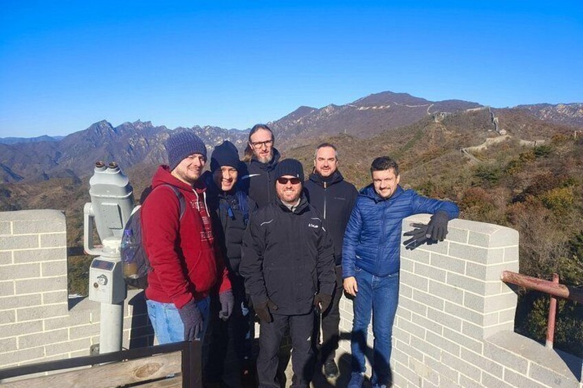 A group of people standing on a high vantage point with a mountainous landscape in the background. 4