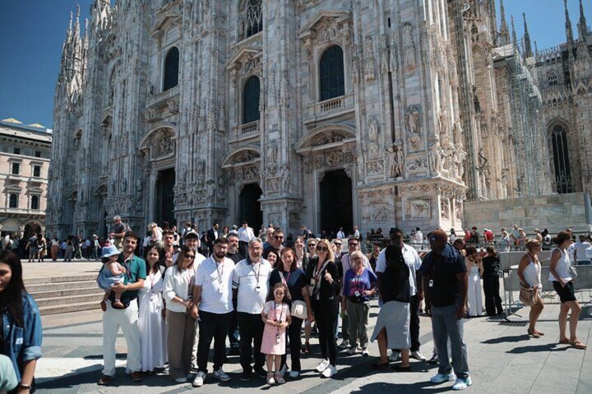 Un grand groupe de touristes se tient devant une imposante cathédrale à l’architecture complexe. 4
