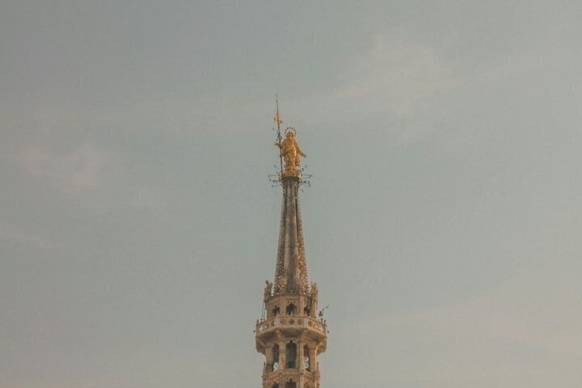 A tall, ornate tower with a spire and a statue on top. 2