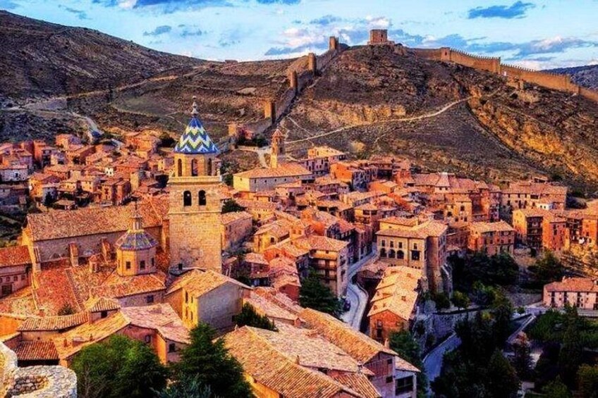 A historic town with a prominent church, a castle on a hill, and terraced buildings. 4