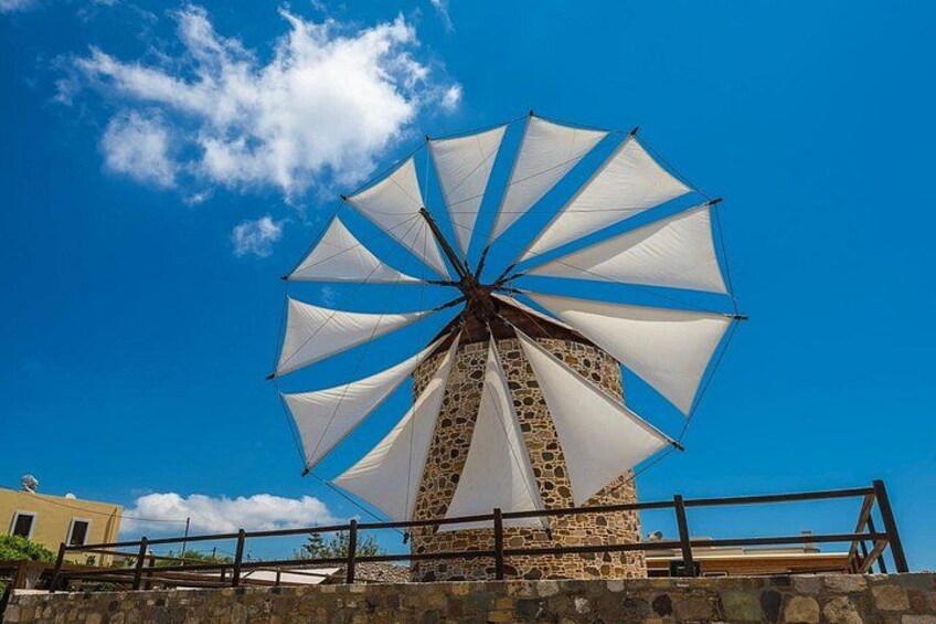 A windmill with white sails against a clear blue sky. 5