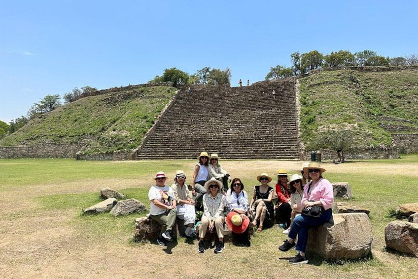 Un groupe de personnes est assis sur des rochers devant une grande pyramide antique. 2