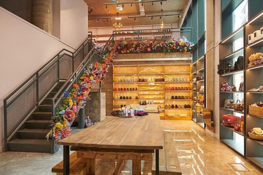 L’intérieur d’un magasin, avec un escalier, une table en bois et des étagères remplies de divers articles. 4