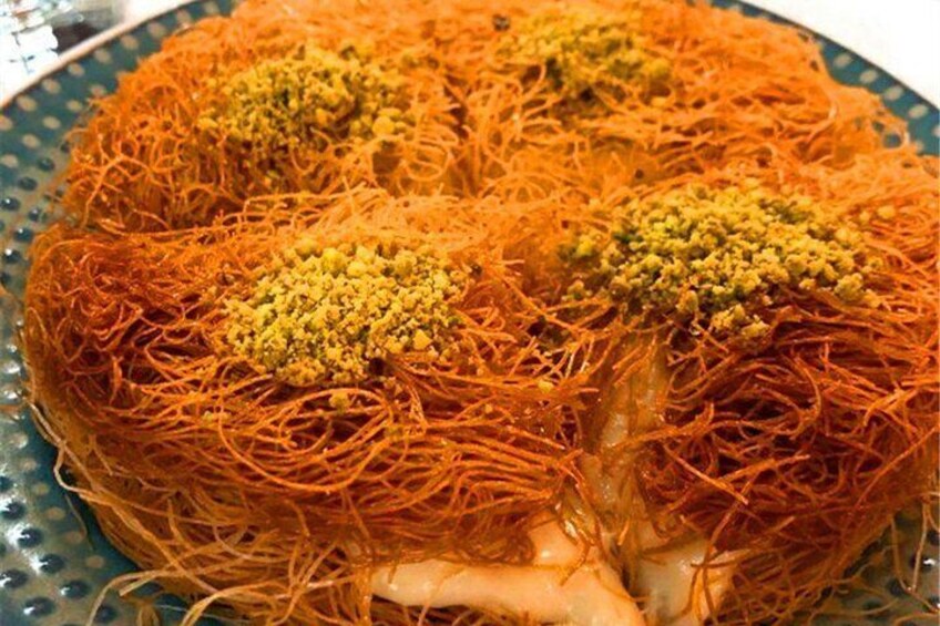 Un plato de baklava con almíbar dorado y nueces picadas. 5