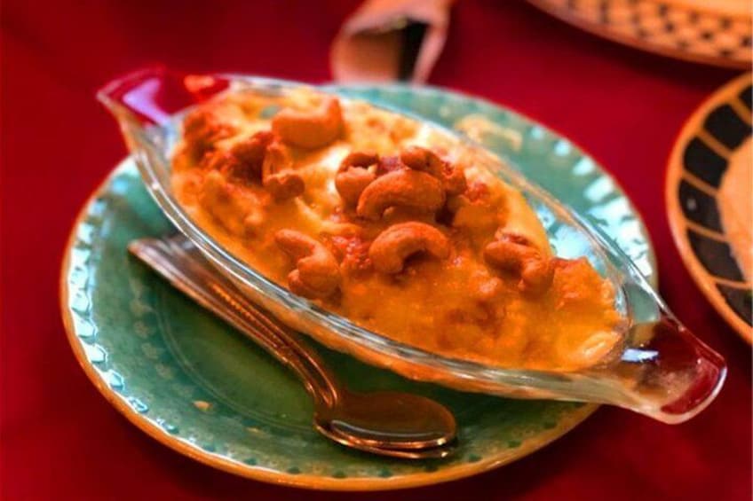 Un plato de curry con anacardos sobre un plato verde. 3