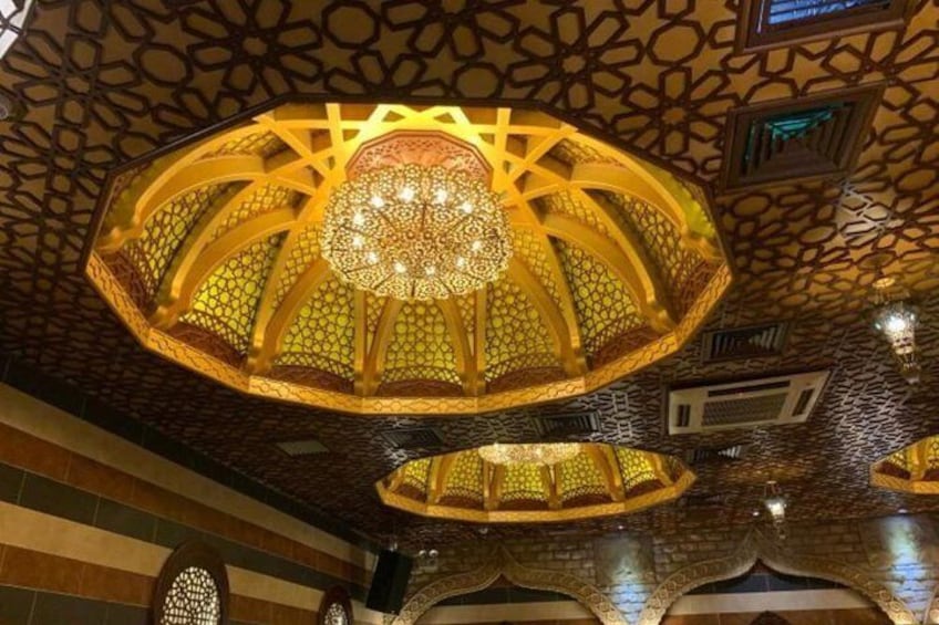 Un techo ornamentado con diseños intrincados y un candelabro central. 2