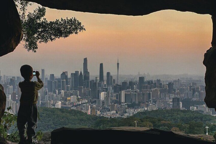 A person taking a photo of a cityscape with a prominent tower. 4