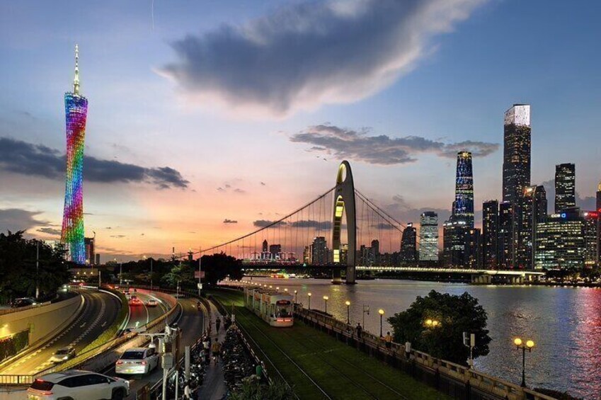A city skyline with a brightly lit tower, a large bridge, and a river. 5
