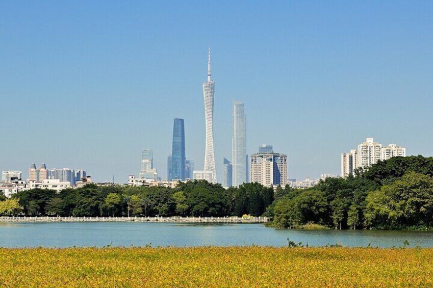 A cityscape with a prominent tower, a body of water, and surrounding greenery. 2