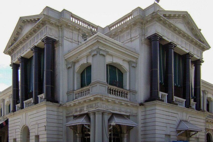 A classical building with Corinthian columns, a balcony, and arched windows. 3