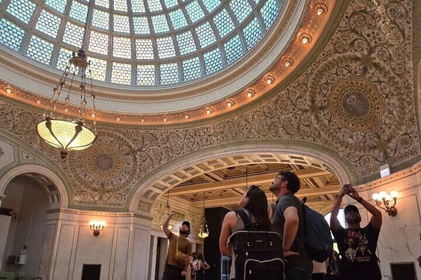 An ornate interior with a domed ceiling and intricate wall designs. 1