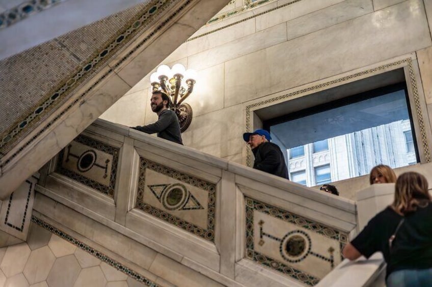 A grand staircase with ornate designs and a candelabra. 4