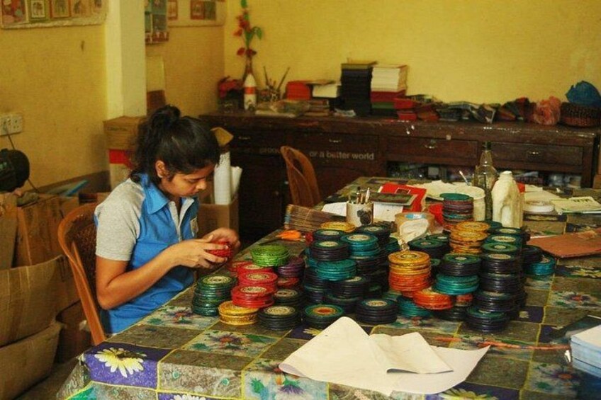 A person sitting at a table with colorful spools of thread. 5