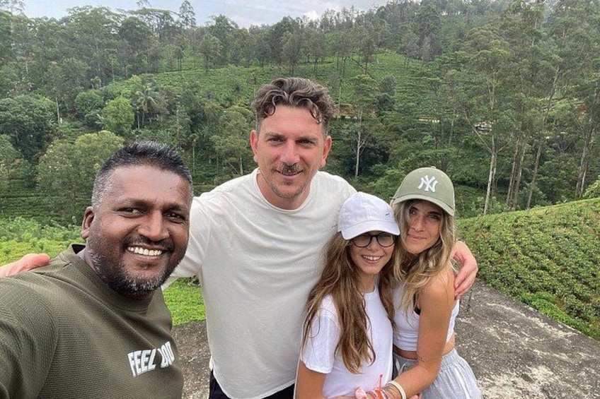 A group of people standing on a path with a forested landscape in the background. 1