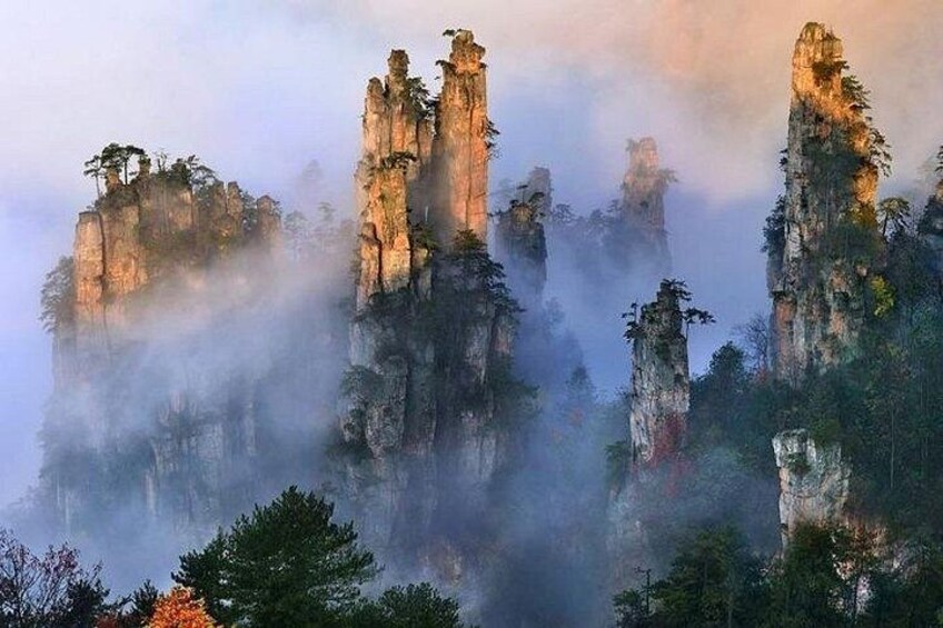 A misty mountain landscape with tall, rugged peaks and sparse vegetation. 1