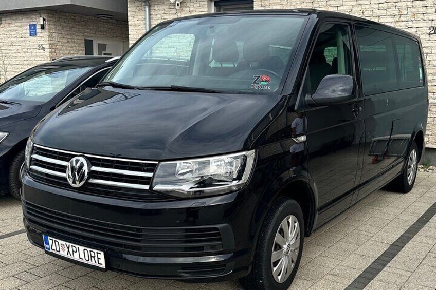 A black Volkswagen van parked in a lot. 2