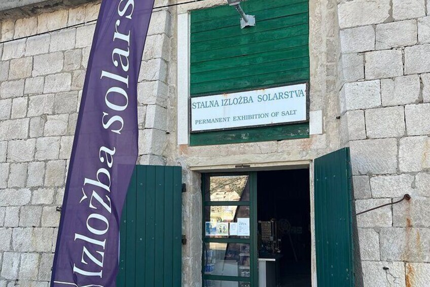 A building with a banner reading "Stalna izložba solarstva" and a sign indicating a permanent exhibition of salt. 3