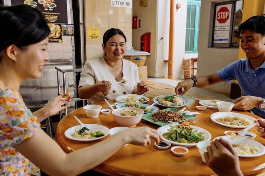 Tres personas sentadas alrededor de una mesa con varios platos. 2