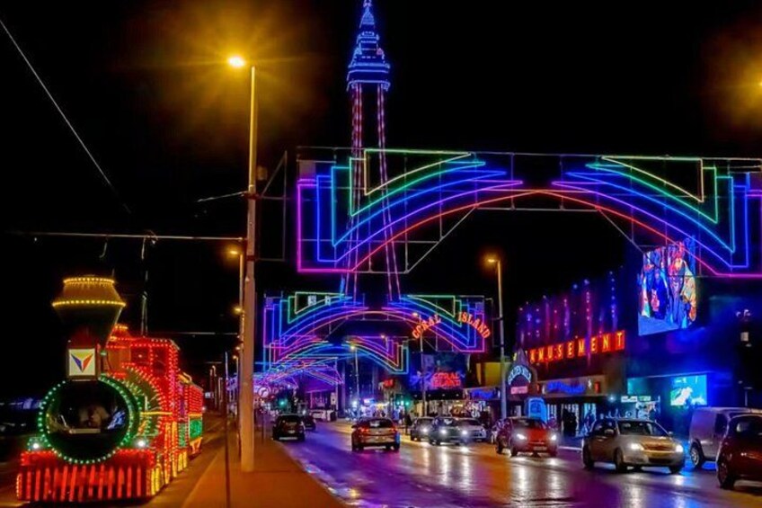 A brightly lit street with colorful neon lights, a prominent tower, and a sign that reads 'Amusement Park.' 2