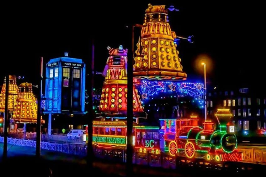 Illuminated buildings with circular patterns and a train with colorful lights. 3