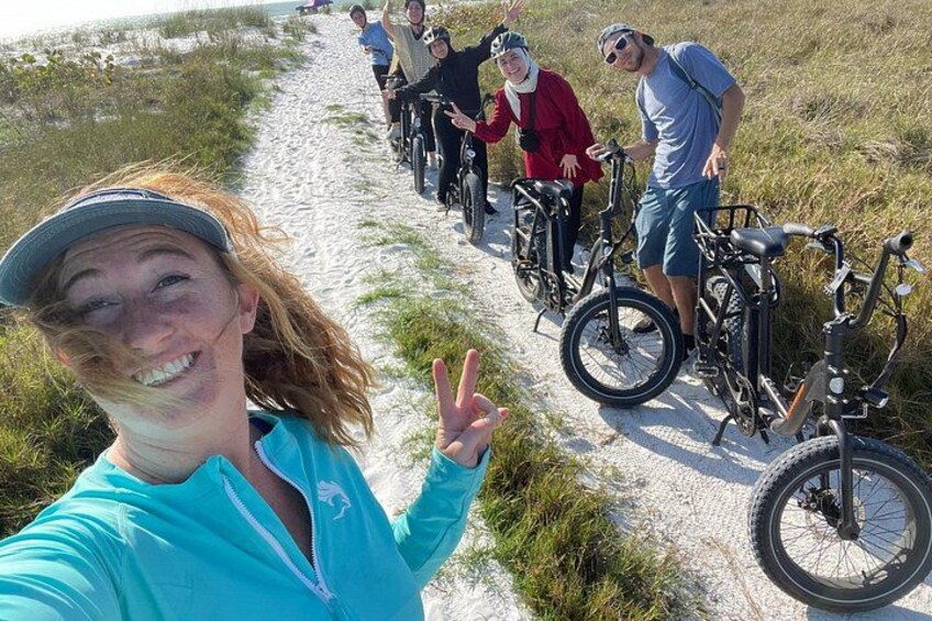 A group of people on a sandy path with bicycles. 5