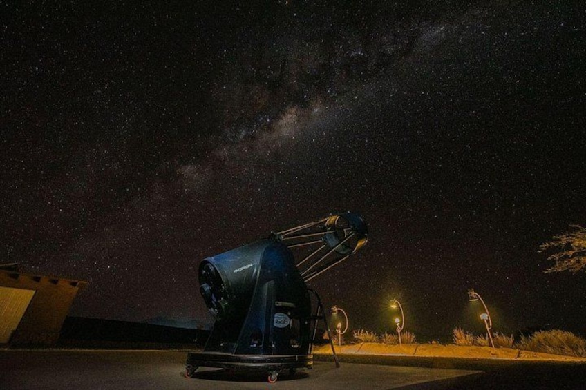 A telescope on a platform under a starry night sky. 3