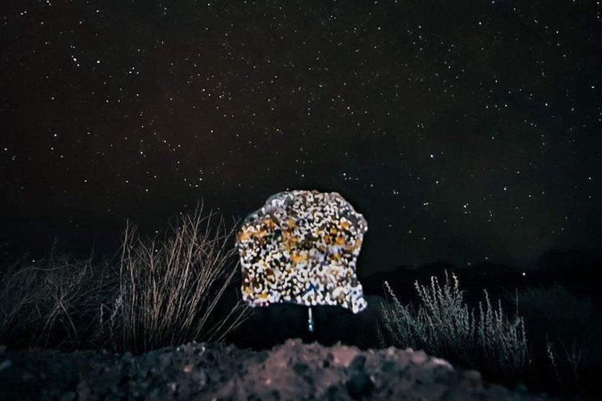 A rock formation with a starry night sky in the background. 2