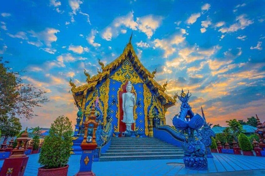 Ett tempel med en stor Buddha-staty, detaljerad arkitektur och en draksskulptur. 3