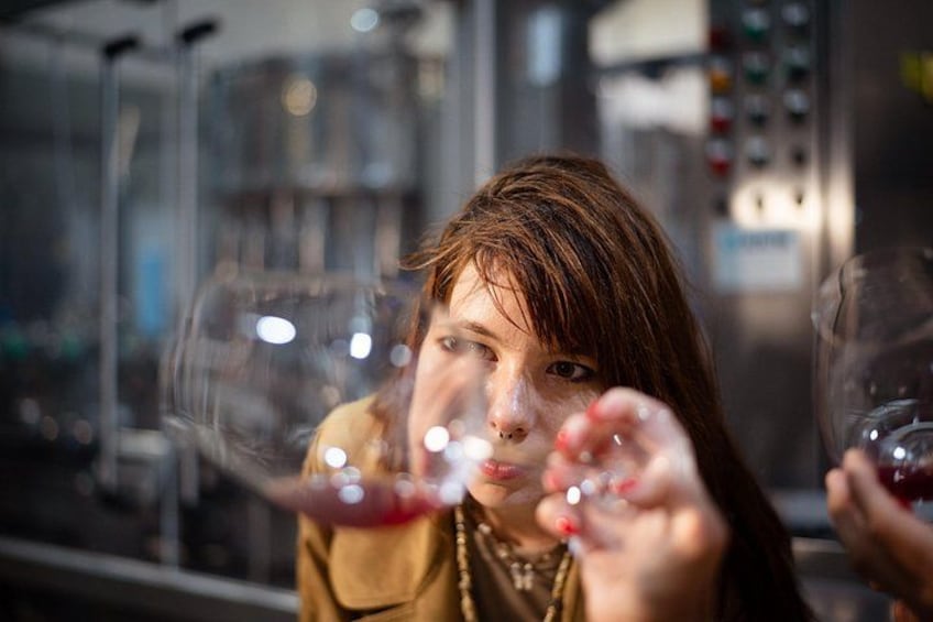 A person blowing bubbles with a glass of red liquid. 4