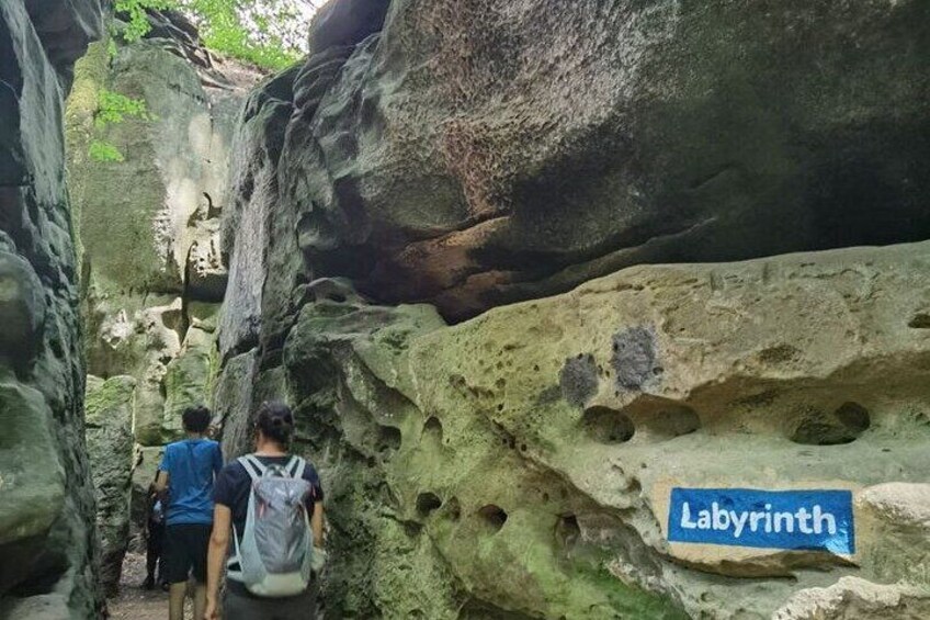 A narrow canyon with large rock formations and a sign reading 'Labyrinth.' 1