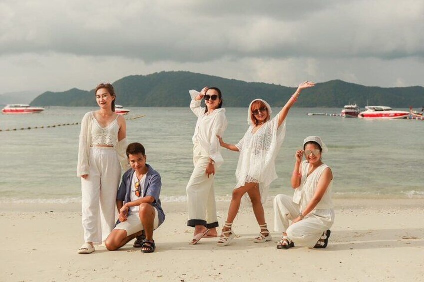 A group of people on a beach with boats in the background. 4