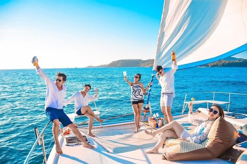 Un groupe de personnes à bord d’un voilier, sous un ciel bleu azur et sur une mer calme. 4