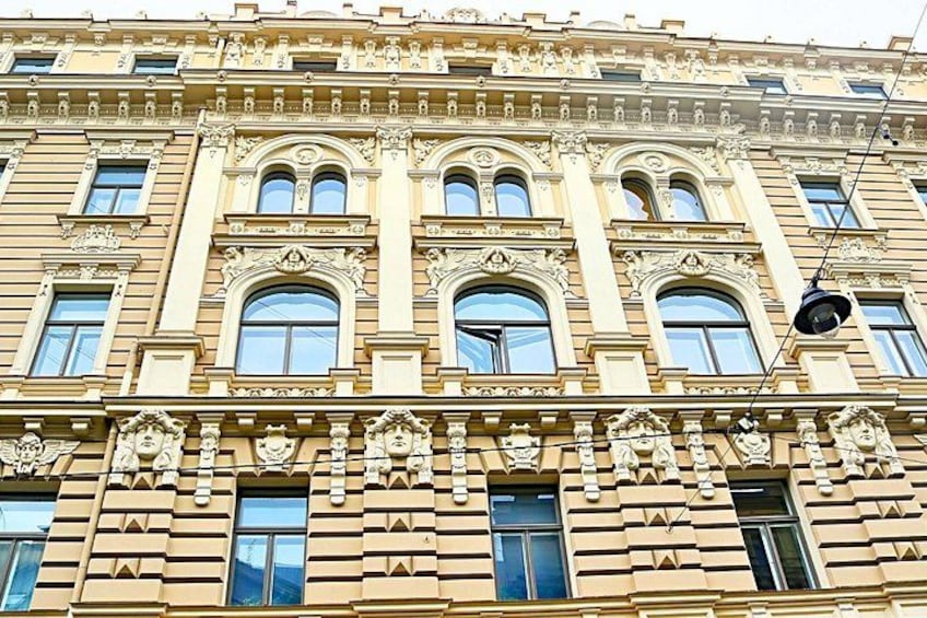A multi-story building with ornate architectural details, including arched windows and decorative sculptures. 4