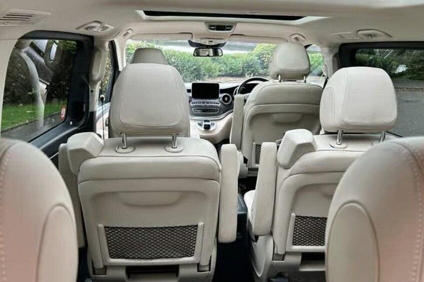 The interior of a car with beige leather seats and a central console. 2