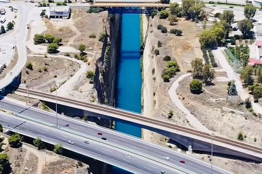 A bridge over a blue water channel, with roads and greenery around. 4