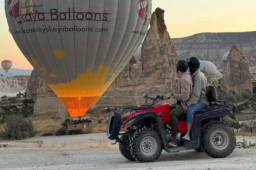A hot air balloon with a website URL, a red ATV with two people, and a rocky landscape with unique rock formations. 3