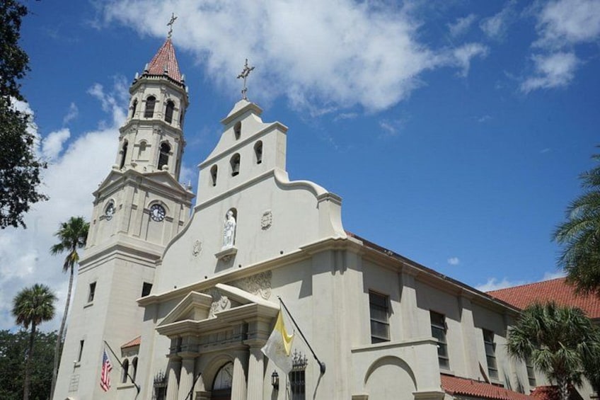Une église dotée d’un clocher et d’une flèche, sous un ciel bleu dégagé. 3