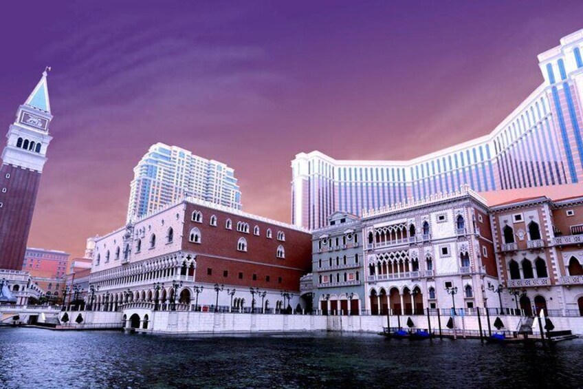 A historic building with arched windows and a red facade, a modern high-rise building, and a tower with a pointed roof. 1