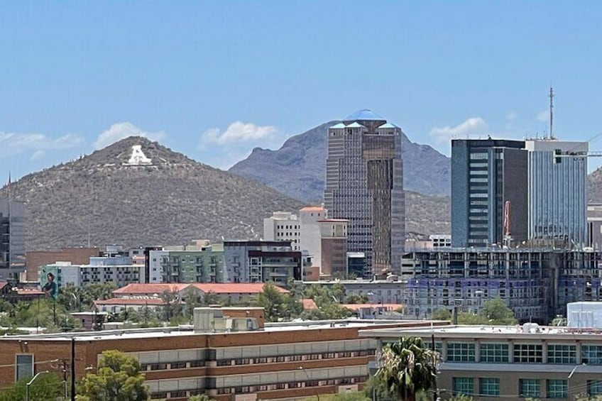 A cityscape with modern buildings, a mountain in the background, and a clear sky. 5