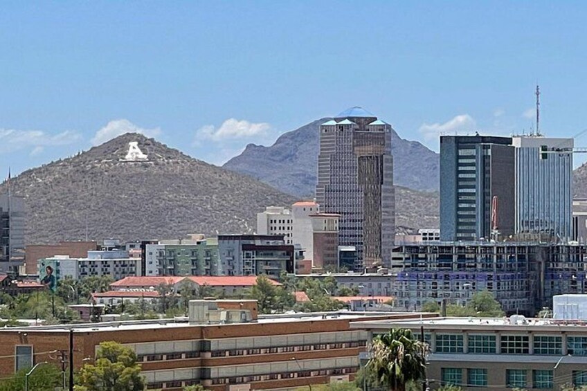 A cityscape with modern buildings, a mountain in the background, and a clear sky. 4