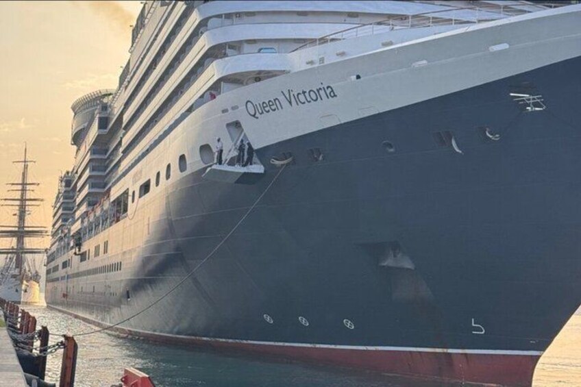 A large cruise ship named 'Queen Victoria' docked at a port. 5