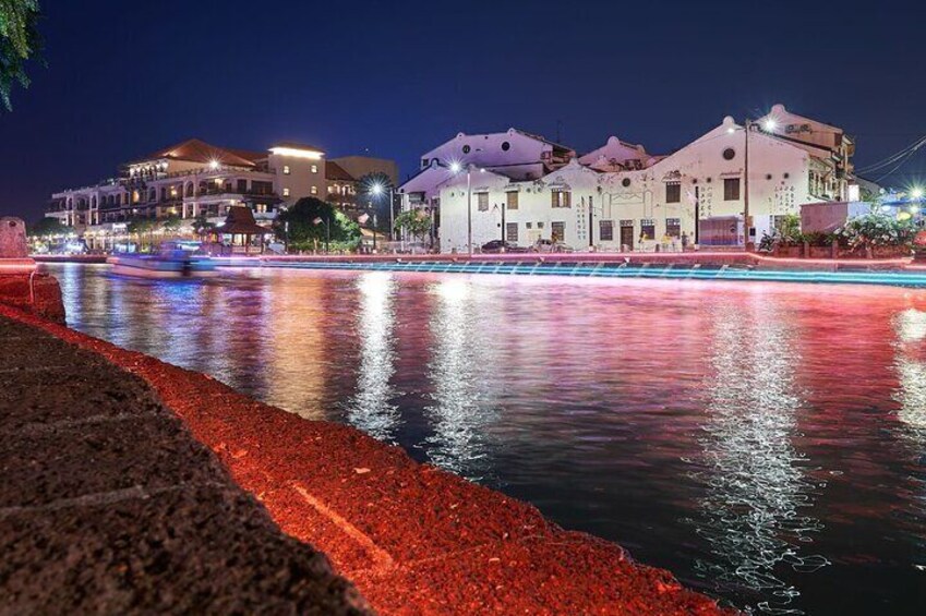 A river with buildings reflecting on the water at night. 4