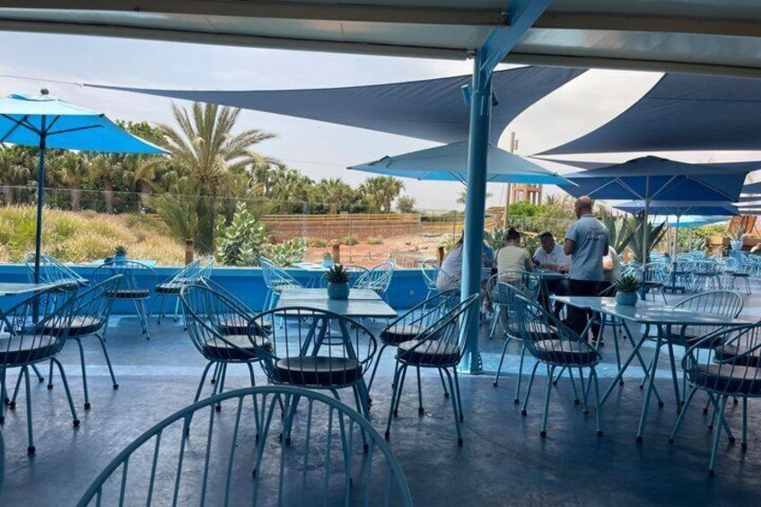 Outdoor seating with umbrellas, metal chairs, and tables. 2