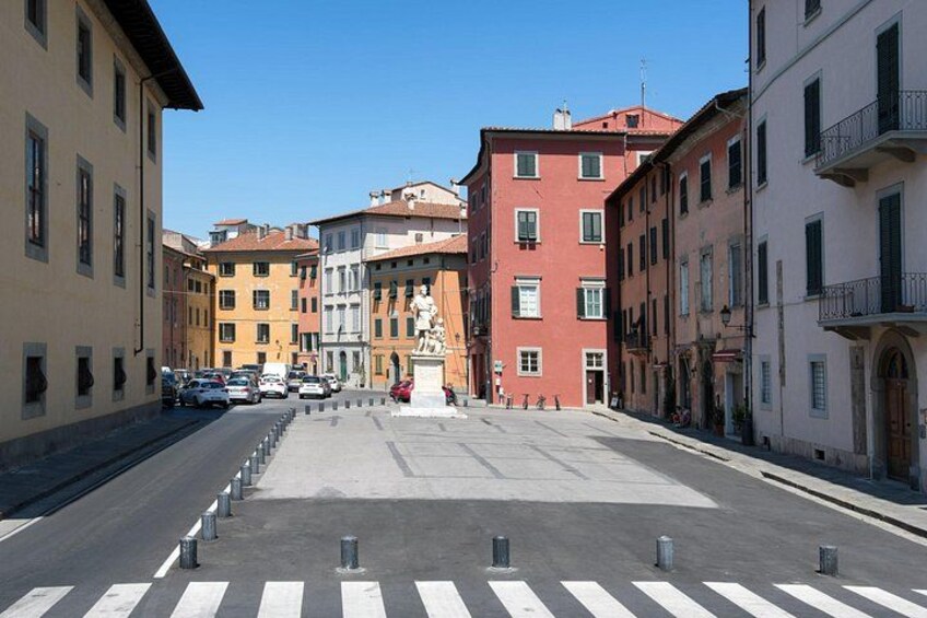 Una calle con edificios, una estatua y un paso de peatones. 2