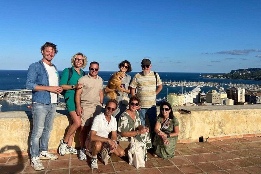 A group of people posing on a rooftop with a cityscape and harbor in the background. 4