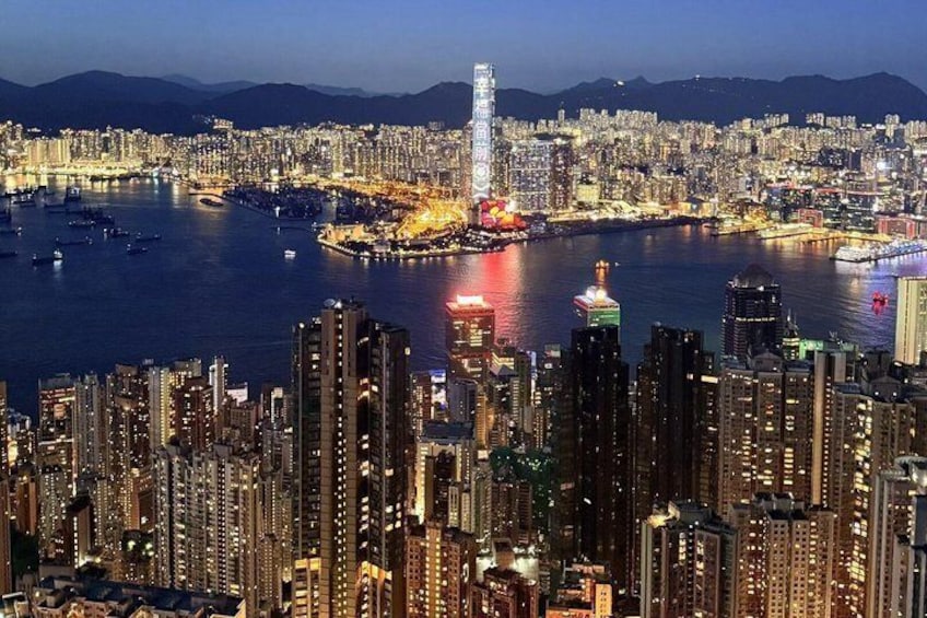 A cityscape with high-rise buildings, a prominent tower, and a body of water with boats. 4