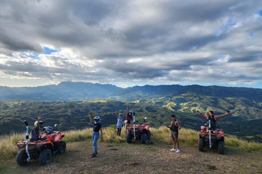 Een groep mensen op een berg met quadbikes, met uitzicht op een vallei. 3